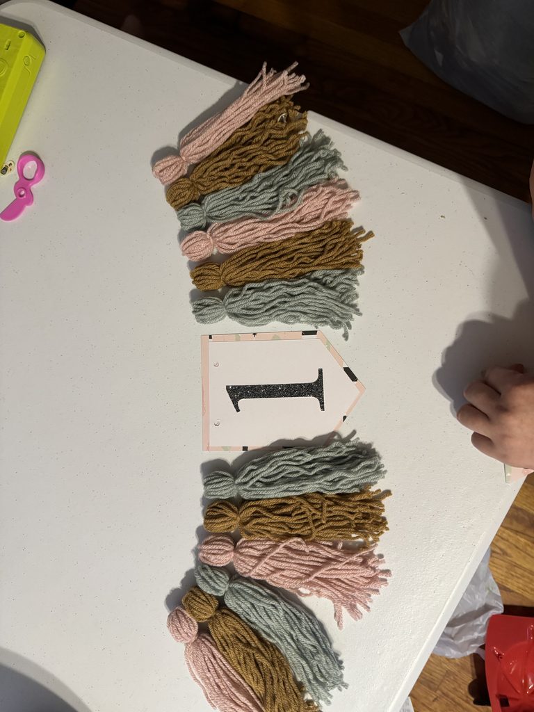 mockup of yarn tassels and glitter one before stringing together for banner