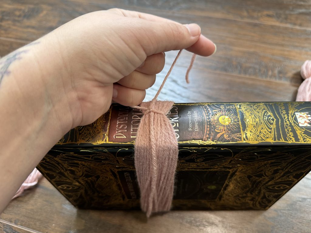 adding a double knot to the yarn before cutting tassel