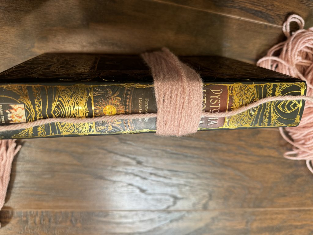 moving the yarn to the book side to tie off for tassel