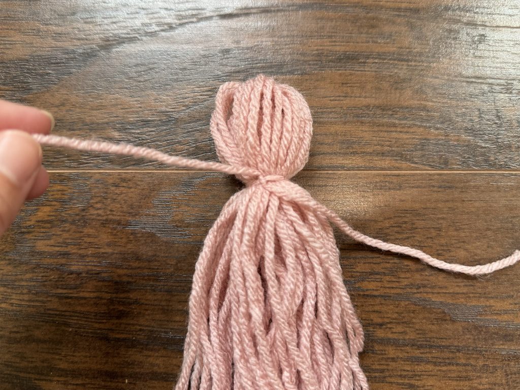 tie off the yarn to create the top of tassel